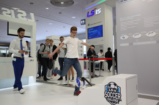 23일(현지시간)부터 닷새 간 독일 하노버에서 열리는 세계 최대 산업전시회 '하노버 메세 2018' 행사장에서 참관객들이 LS산전의 DC(직류)아일랜드 ESS(전력저장장치) 충전 체험 게임을 하고 있다. <LS산전 제공>